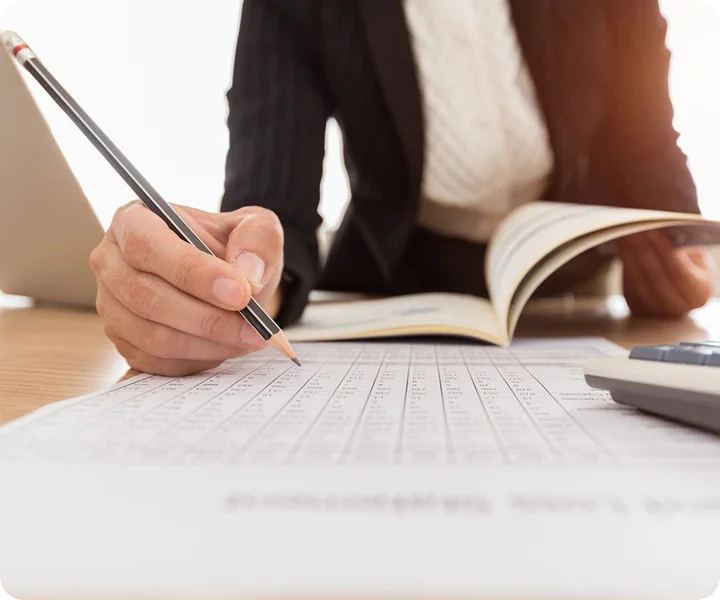 A person writing on paper with a pencil