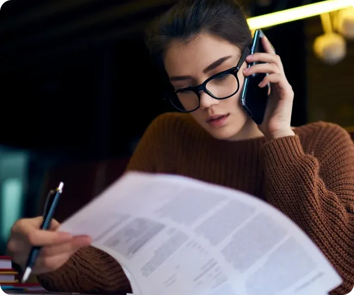 A woman is on her cell phone and reading.